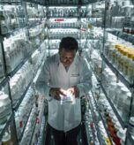 Photo of a pharmacist in a busy pharmacy, preparing a prescription with the help of automated dispensing equipment. The scene is shown from a view from bottom to top, focusing on the pharmacist’s precise work and the advanced equipment used for medication preparation. --chaos 13 --ar 4:3 --stylize 300 Job ID: e41d5348-7813-4e97-8ca1-b91fecf038c9