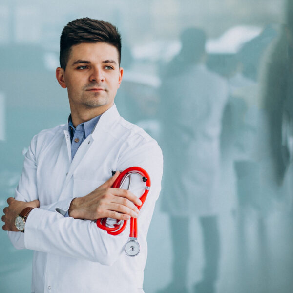 Young handsome physician in a medical robe with stethoscope